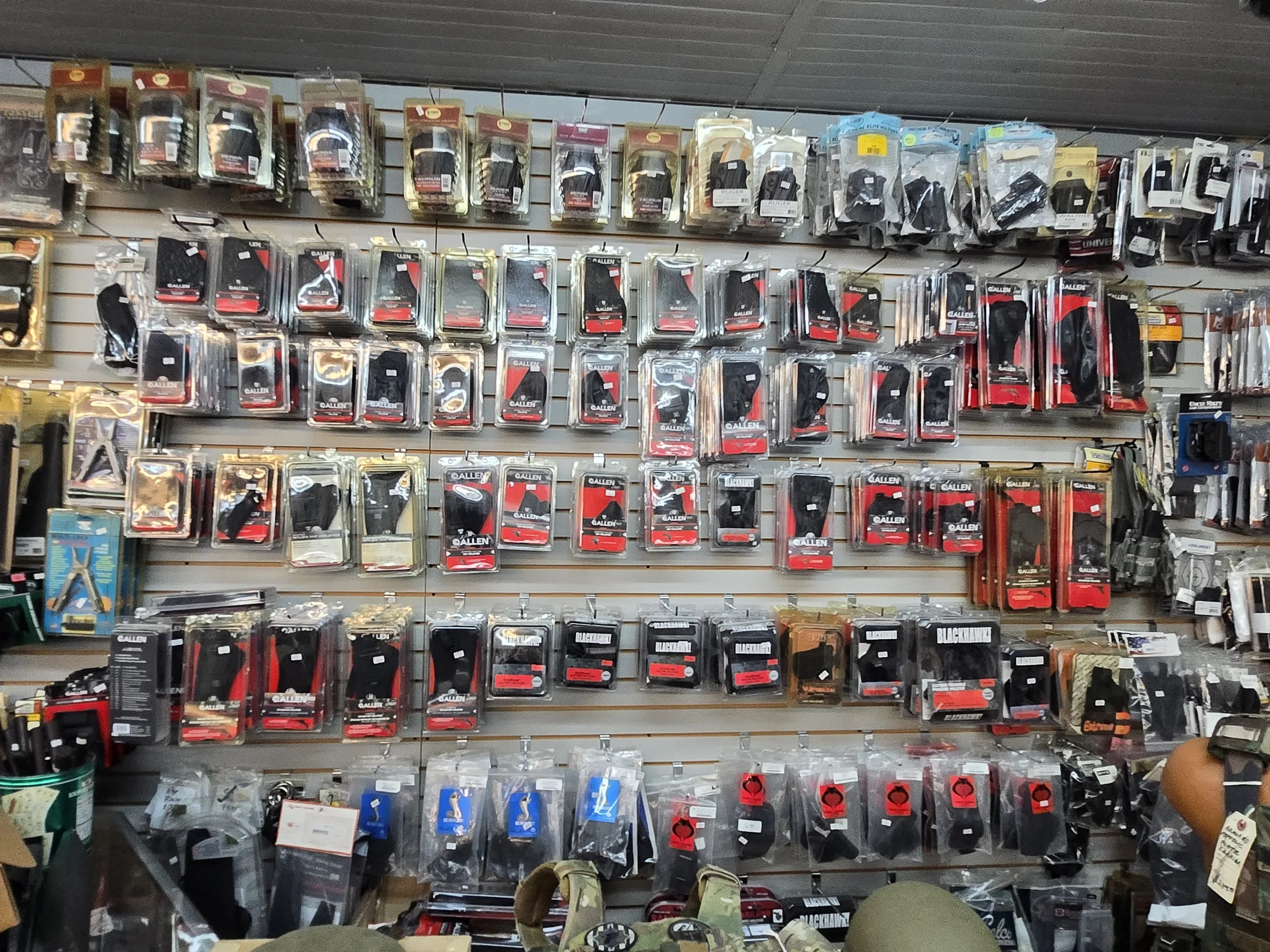 Wall of holsters and carry accessories at AAA Gun & Pawn