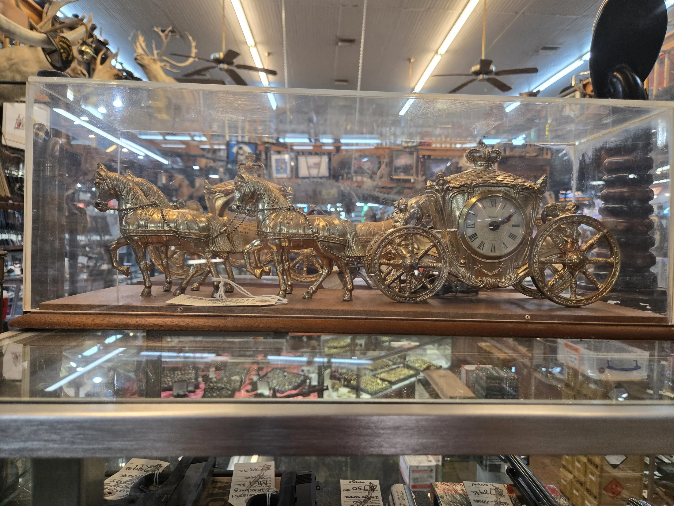 Gilt horse-drawn carriage clock in a glass case at AAA Gun & Pawn