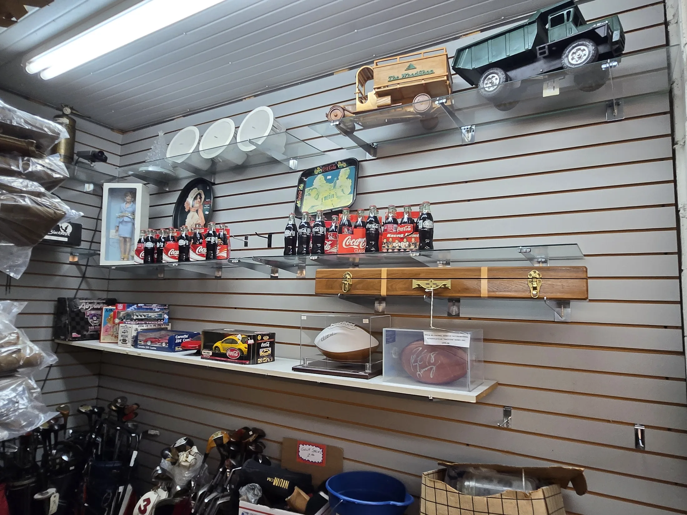 Coca-Cola collectibles and memorabilia on shelves at AAA Gun & Pawn