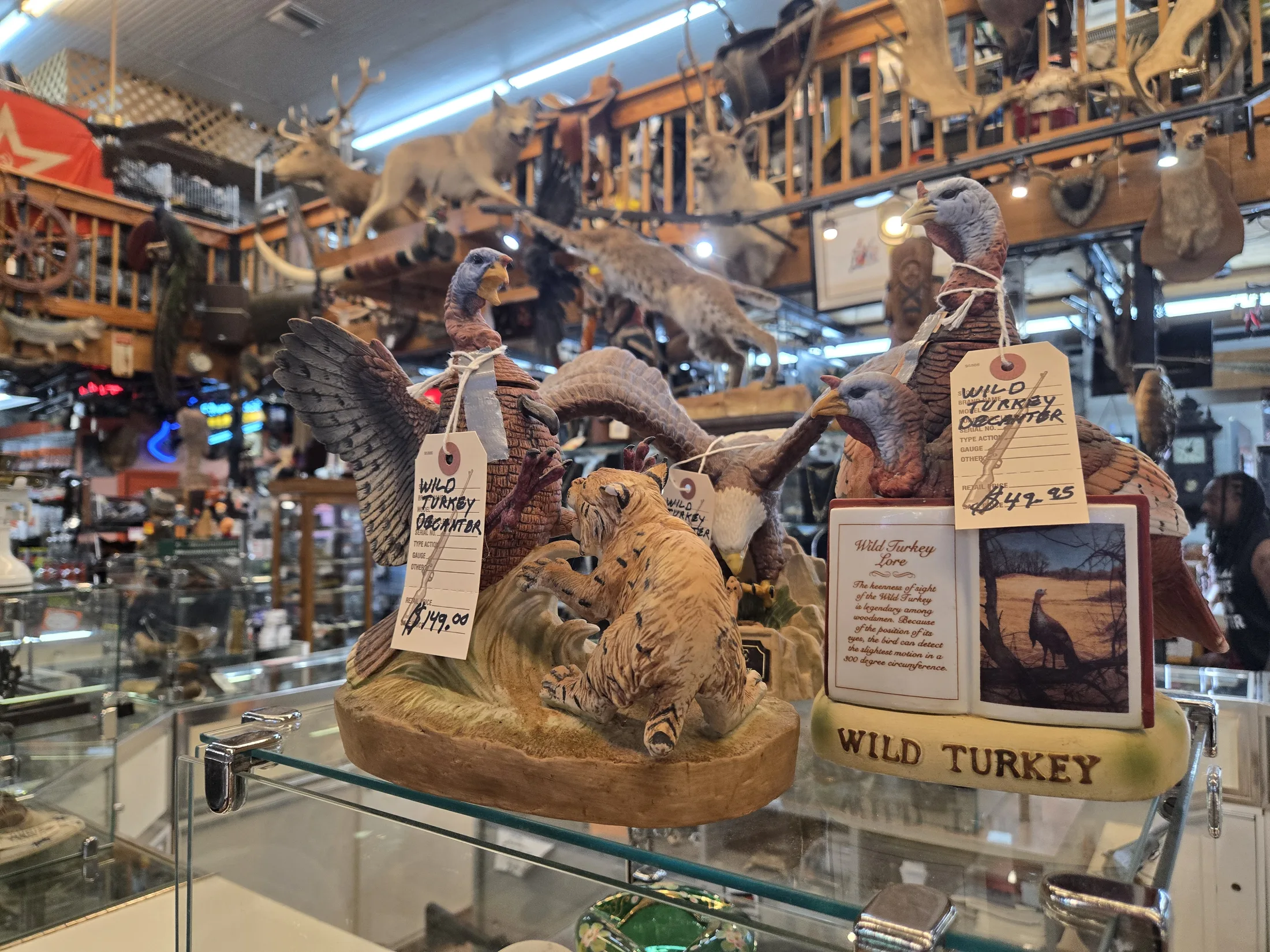 Collectible decanters and figurines in a glass case at AAA Gun & Pawn