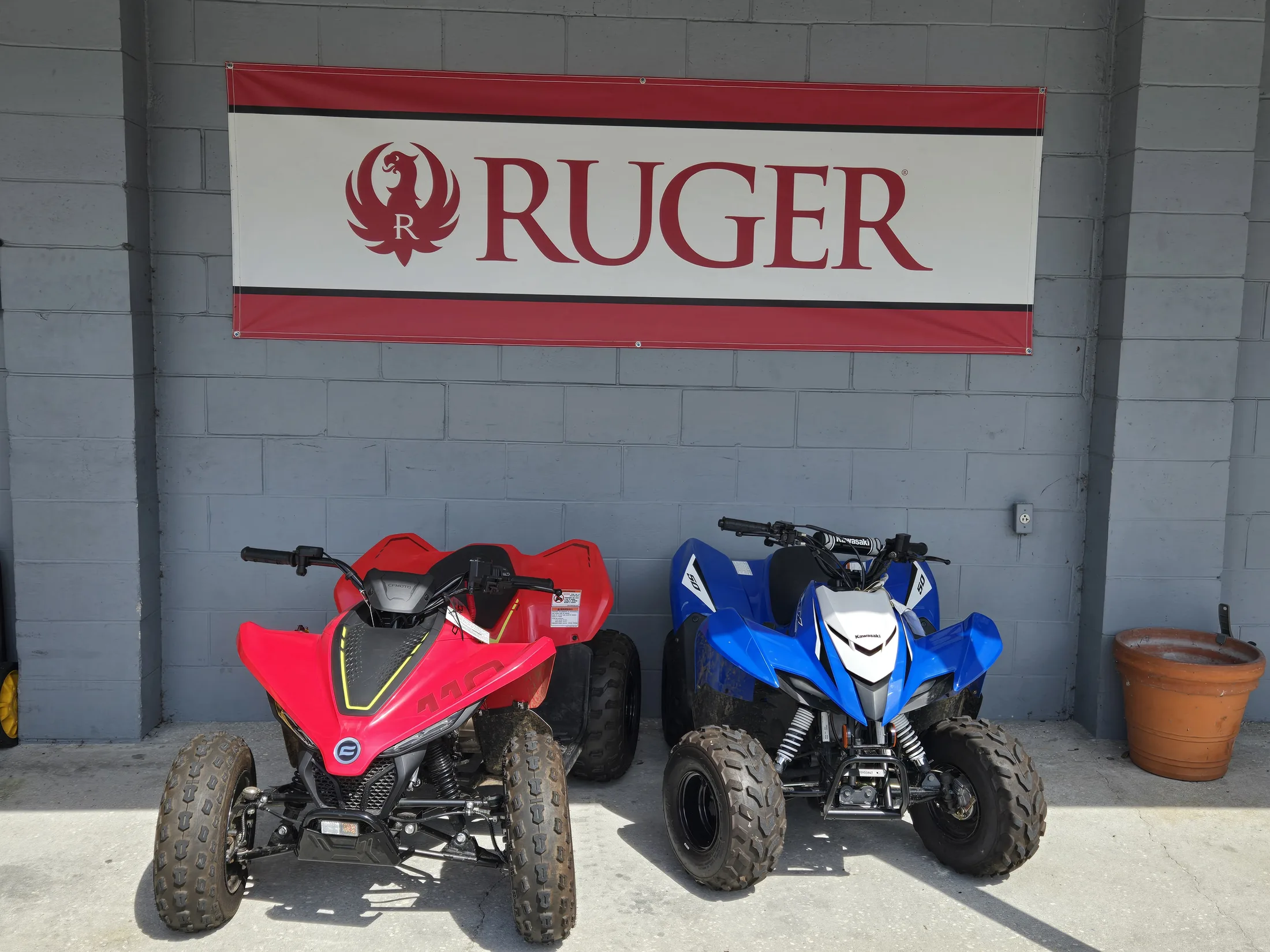 Two youth ATVs parked under the Ruger banner outside AAA Gun & Pawn