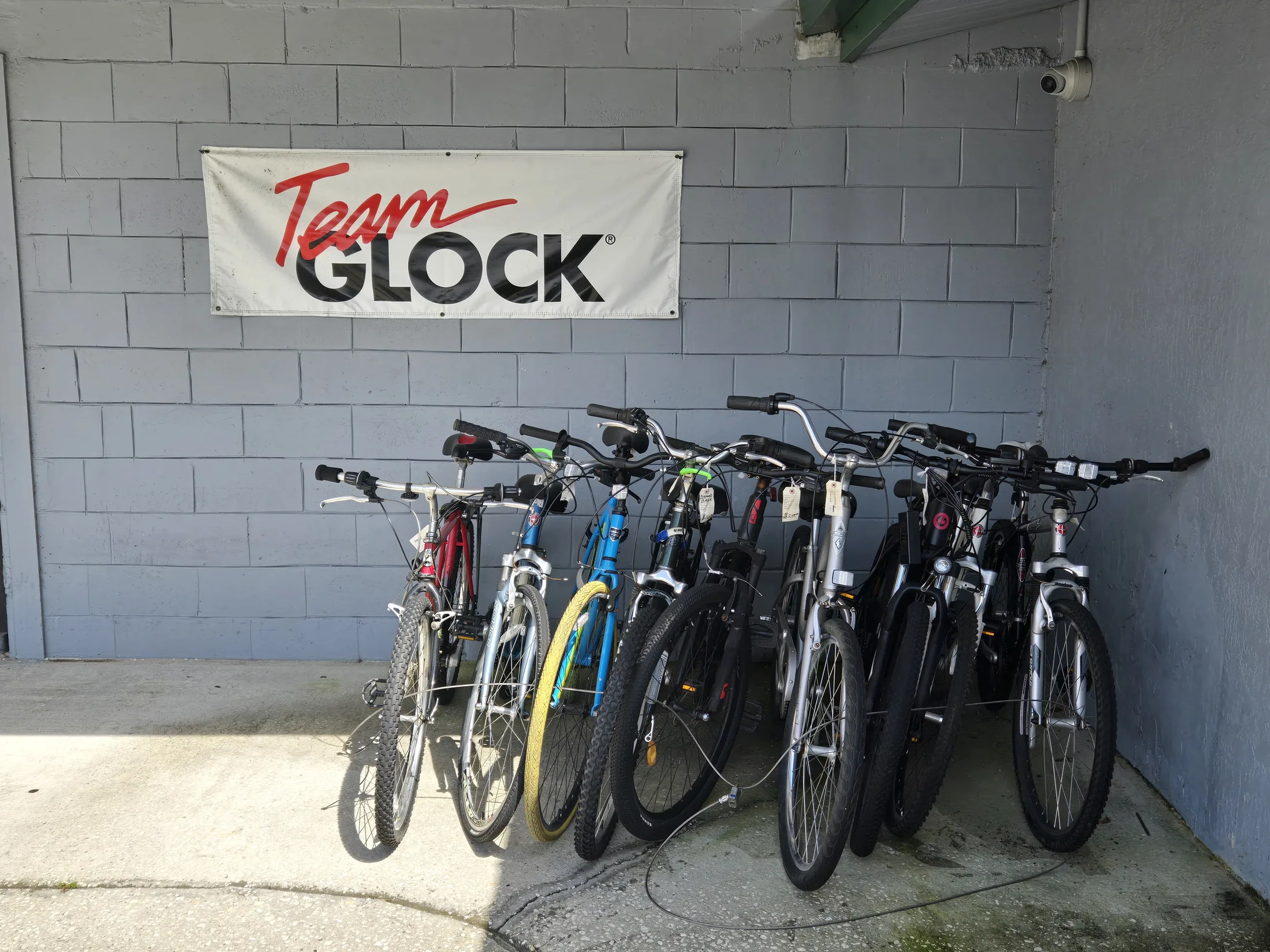 Bicycles lined up outside AAA Gun & Pawn beneath the Team Glock banner