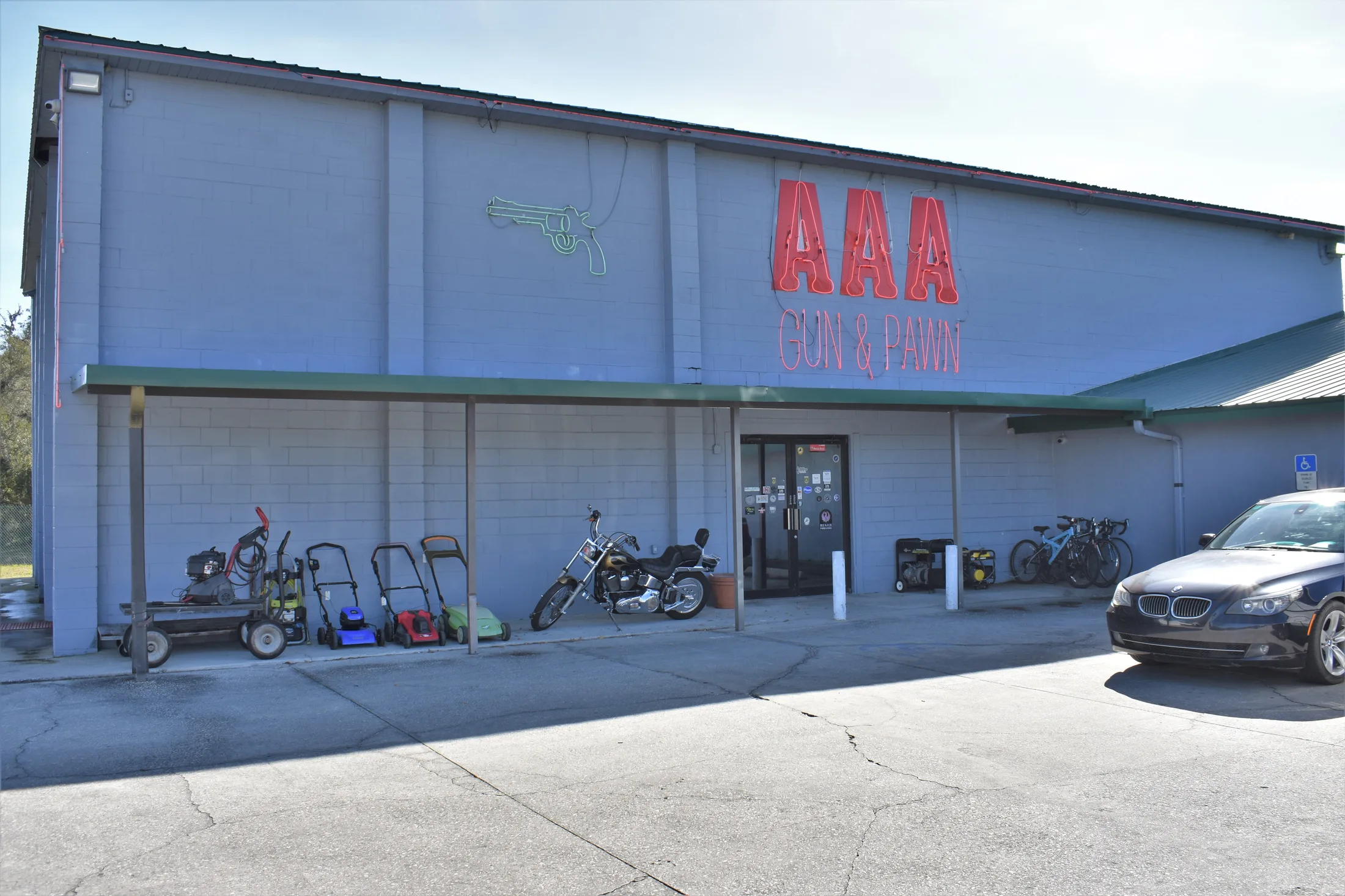 Front entrance of AAA Gun & Pawn with the AAA sign above the covered walkway