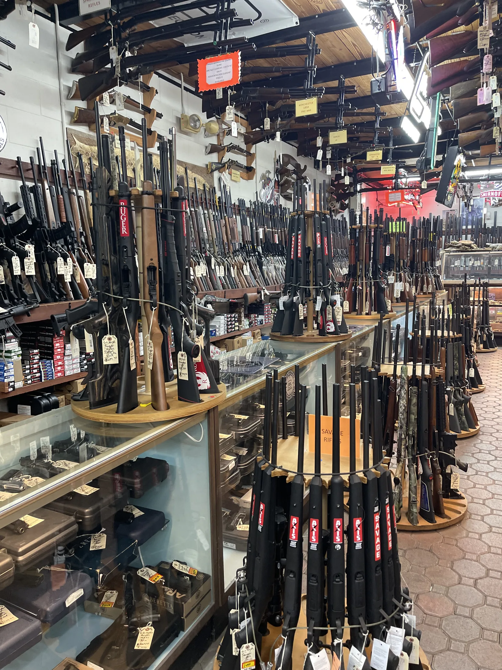 Rifles displayed on a counter and racks at AAA Gun & Pawn