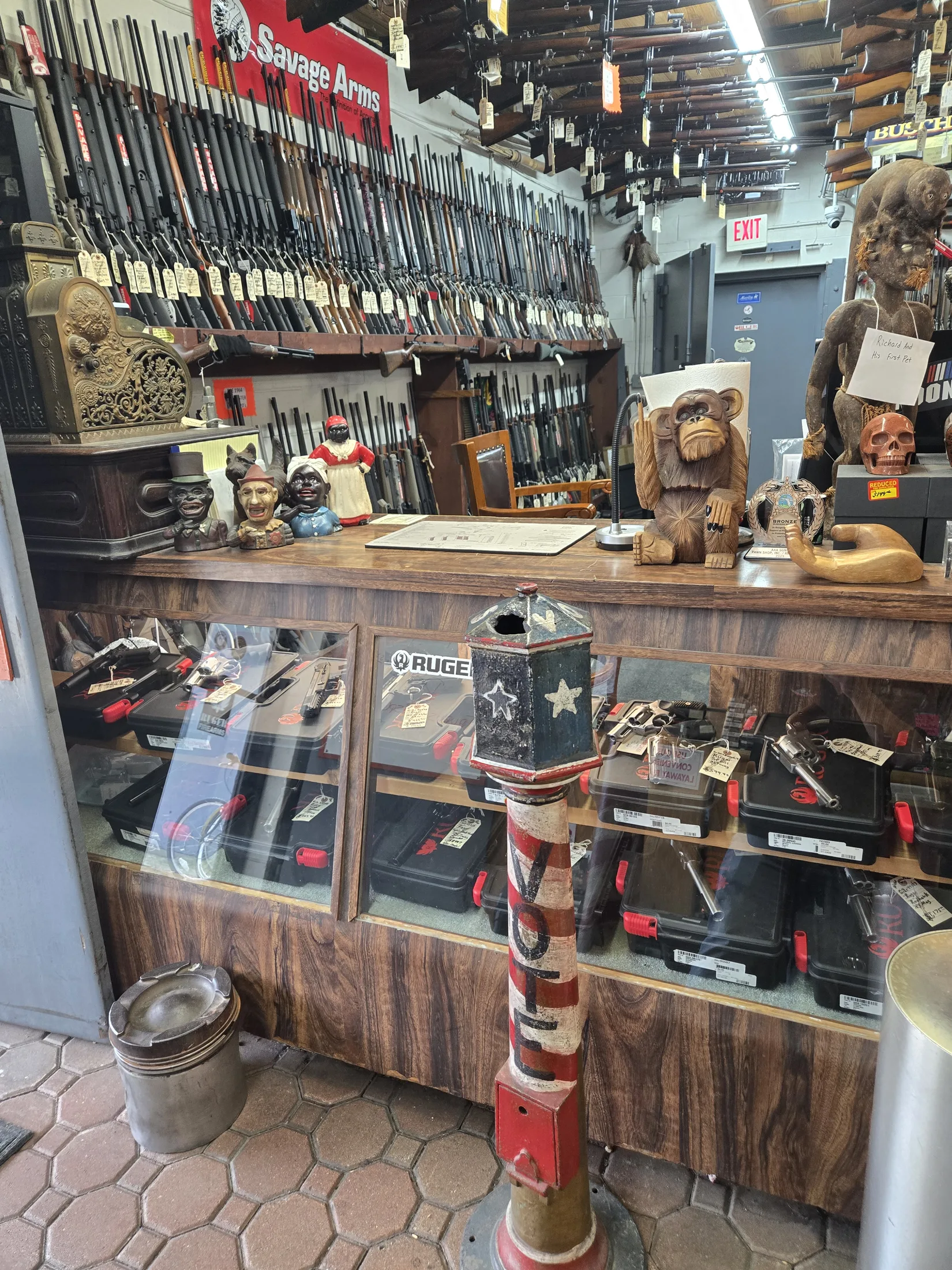 Firearms counter at AAA Gun & Pawn with the long-gun wall behind