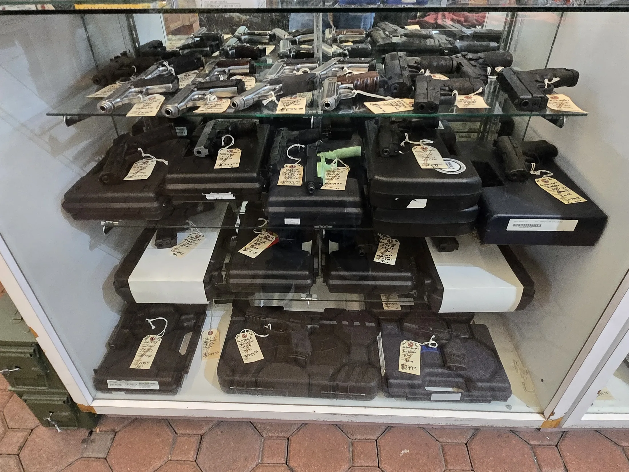 Handguns displayed in a glass showcase at AAA Gun & Pawn