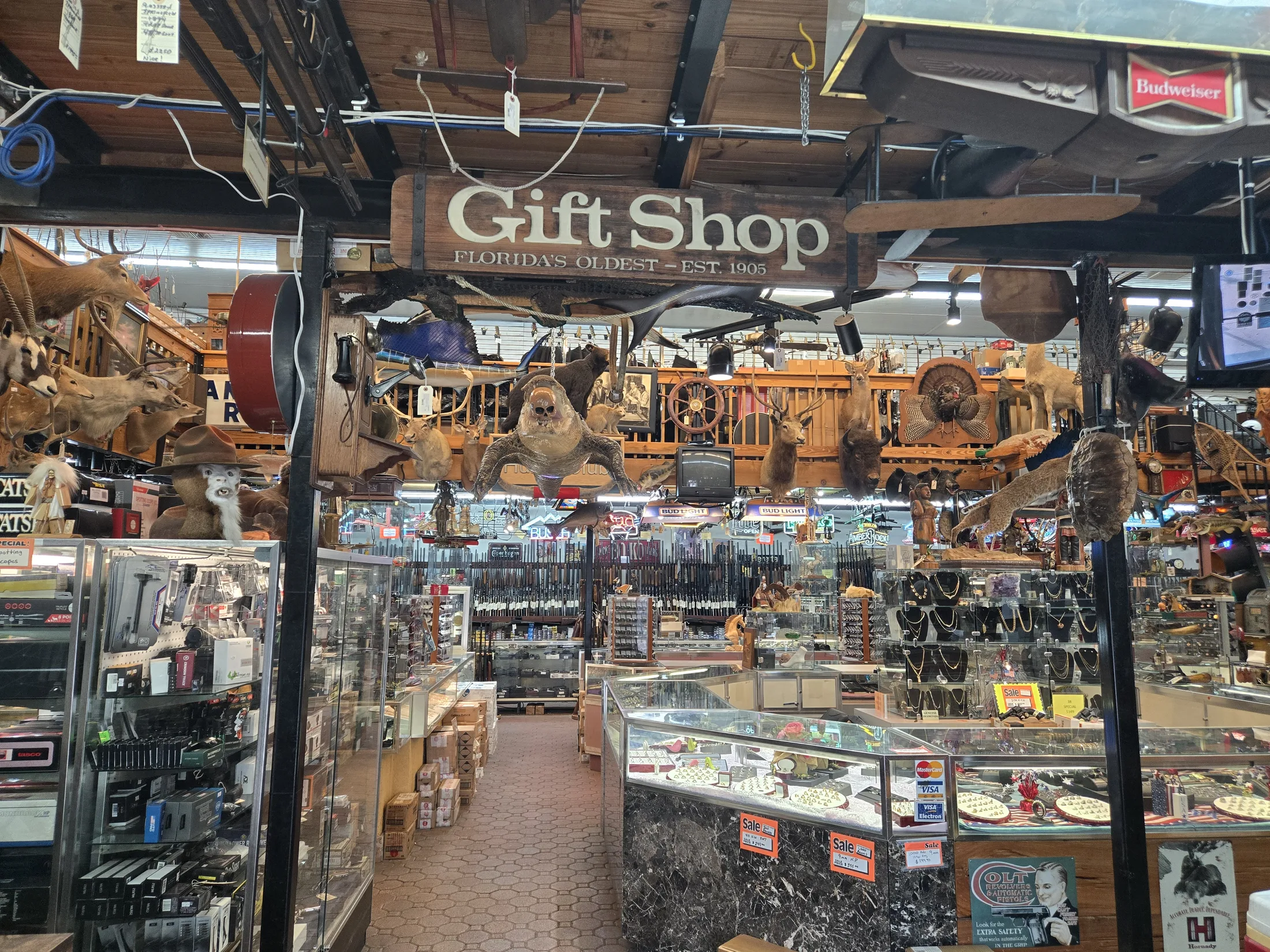 Gift shop sign over showcases and merchandise inside AAA Gun & Pawn
