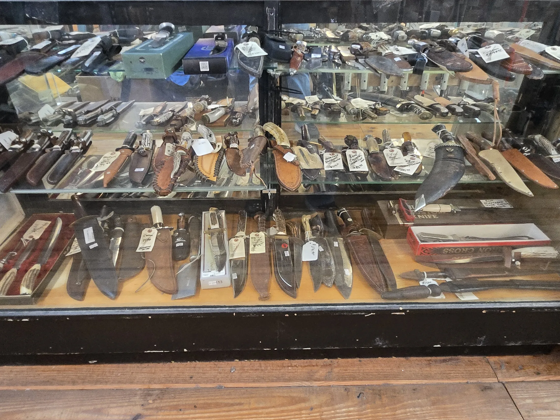 Fixed-blade knives in a display case at AAA Gun & Pawn