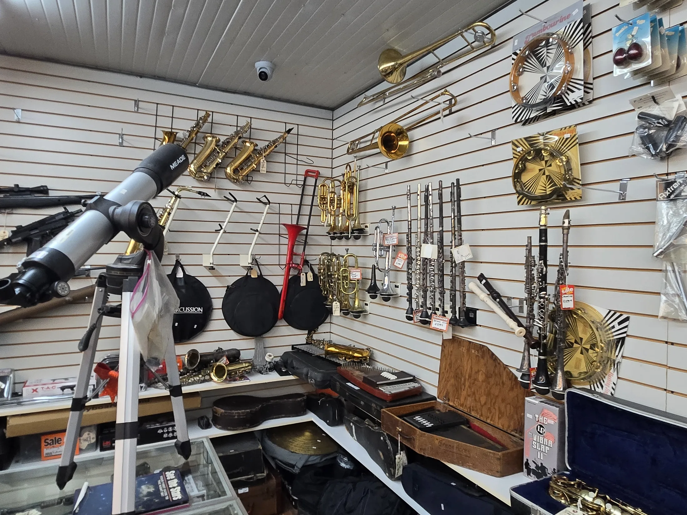Trumpets, clarinets, cymbals and other instruments on the wall at AAA Gun & Pawn