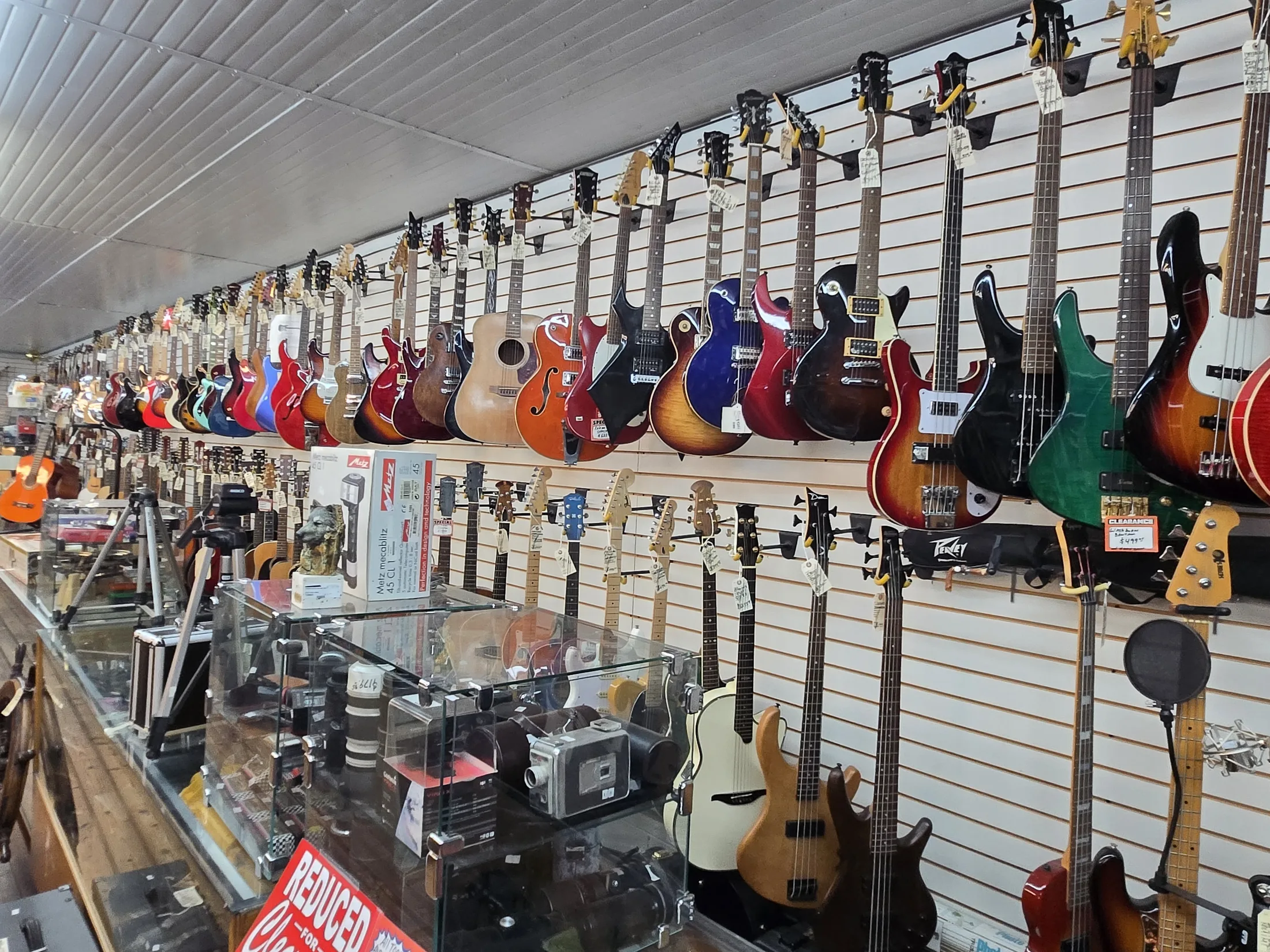 Wall of electric and acoustic guitars inside AAA Gun & Pawn